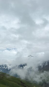4K Vertical shot of clouds covering the Himalayan mountain range during the monsoon season as seen from Sissu in Lahaul and Spiti district, Himachal Pradesh, India. Scenic view of mountains in monsoon