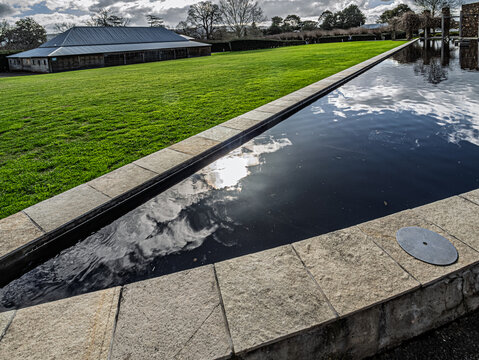 Triangular Pool Reflects Cloudy Sky.