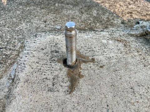 Steel Anchor Bolt Embedded in Concrete Floor Base for Heavy Industrial Construction and Structural Fastening