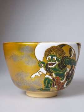 Traditional Japanese gold ceramic tea bowl (Chawan) featuring hand-painted Fujin the Wind God