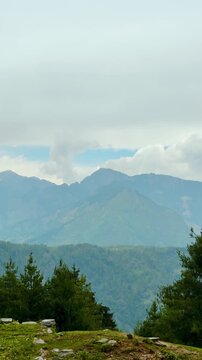 4K Vertical shot of Himalayan mountain range with clouds above it during the monsoon season as seen from Kais Dhar near Kullu in Himachal Pradesh, India. Scenic view of Himalayas in monsoon season.