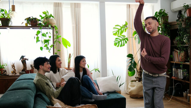 Diverse friends enjoying charades game in a comfortable home, fostering entertainment and connection