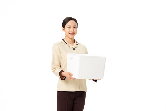 Smiling housekeeping worker holding white storage bin