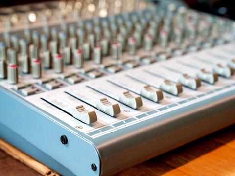 Close-up of audio mixing console with faders and knobs. Professional recording studio equipment for sound engineering and music production. Selective focus on front sliders for a clean look.