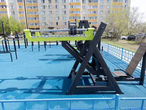 Lime-green and black outdoor gym equipment idle in a residential apartment complex