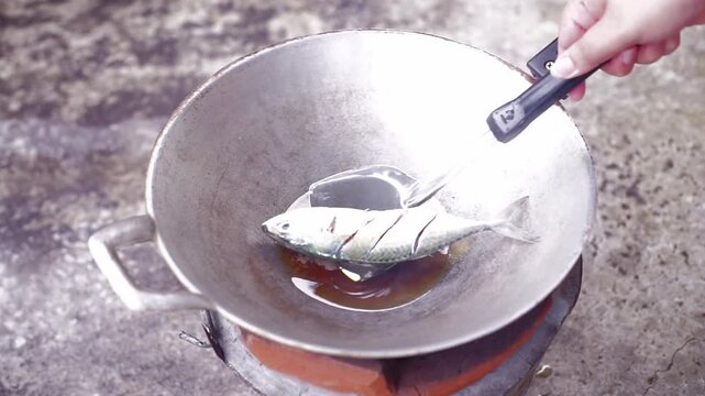 Traditional Thai cooking over charcoal, featuring spicy deep-fried fish and authentic local cuisine.