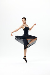 Young ballerina in black dress dancing on pointe in studio © LuuNhan