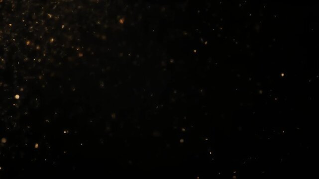 A dark background with numerous small, glowing specks of light scattered across it.