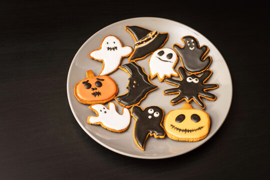 Lots of Halloween gingerbread cookies in a plate on a dark background. Homemade Halloween gingerbread cookies