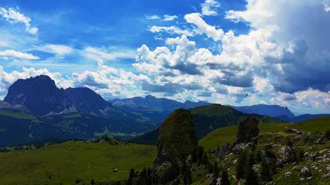 View of beautiful landscape in the Alps with fresh green meadows and mountain tops in the background on a sunny day with blue sky and clouds in summertime. Alpe di Cisles, Seceda Ridgeline, Dolomiti ,