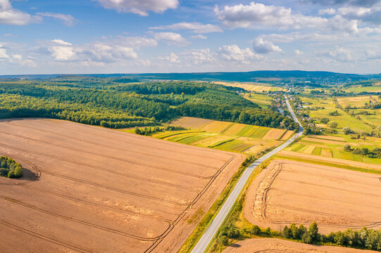 Aerial view of the countryside. Highway and cultivated wheat fields on the hills