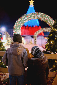 Brothers watching colorful Christmas lights at night