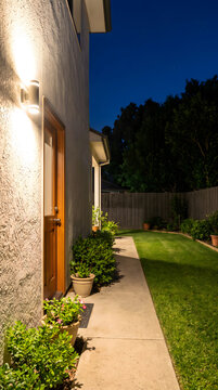 Night view of residential backyard with concrete pathway