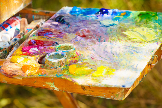Bright palette filled with colors ready for painting outdoor scenery on a sunny day