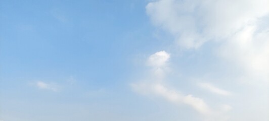 Obraz premium Clear blue sky with bright white fluffy clouds on a beautiful sunny day. Natural scenery background with beautiful white clouds and clear blue sky.