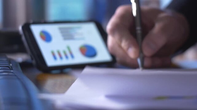 Accountant Working on Tax Forms and Financial Calculations at Office Desk
