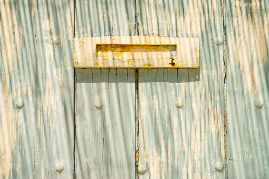 Wooden door with old rusty postbox