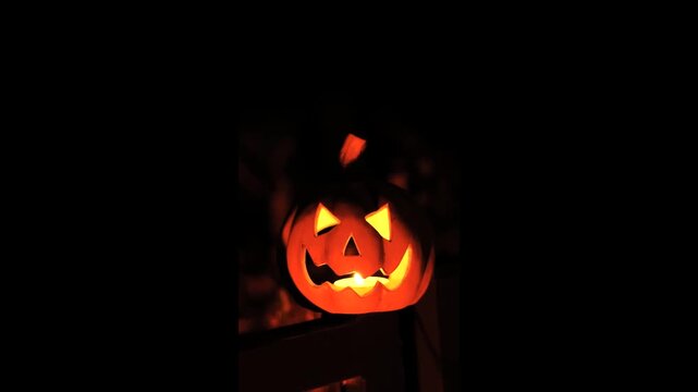 Halloween lantern glowing in a dark setting illustrating mysterious festive light, an autumn mood and a spooky pumpkin face atmosphere. 