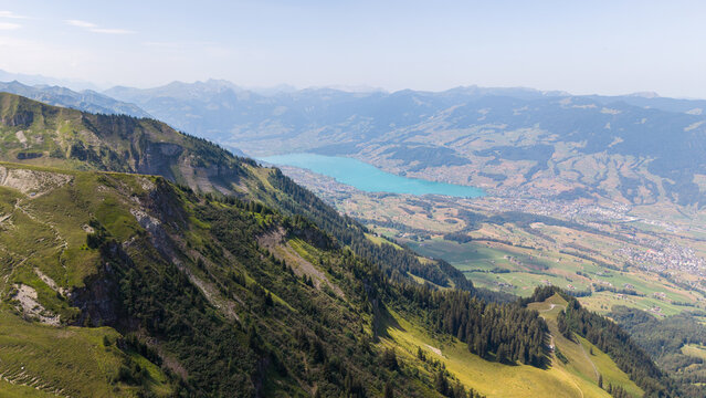 Panoramic view over Lake Sarnen from the Arvigrat ridge in Central Switzerland, with green alpine slopes, valleys and mountain ranges on a clear summer day.