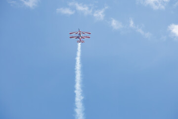 Red and White Aerobatic Biplane Flying Against Blue Sky with Clouds, upside down © Heino Eisner