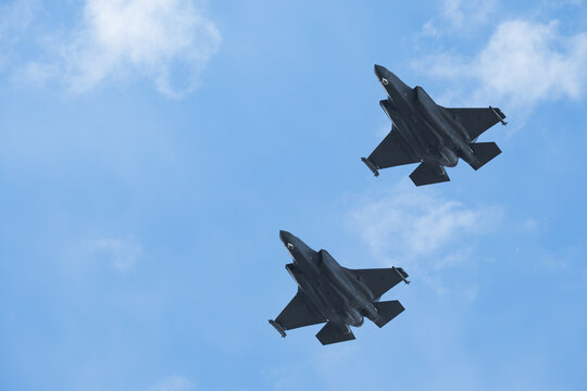 Two F-35 Fighter Jets Flying in Formation Against Blue Sky