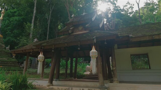 Entrance to Wat Phra Lat Buddhist temple by tropical forest in Chiang Mai Thailand, Traditional monastery architecture with peaceful garden courtyard and lush greenery at sunset 4k