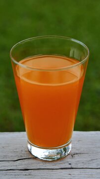 Fresh orange juice in a glass under natural sunlight