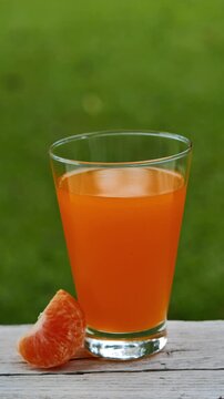 Fresh orange juice in a glass under natural sunlight