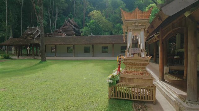 Sacred courtyard with traditional temple buildings at Wat Phra Lat, Buddhist monastery surrounded by tropical forest and peaceful garden lawn, Chiang Mai, Thailand 4k