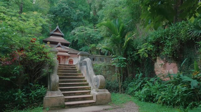 Temple staircase to peaceful shrine in tropical forest, Traditional Buddhist Wat Phra Lat sanctuary by lush jungle garden, Chiang Mai Thailand 4k