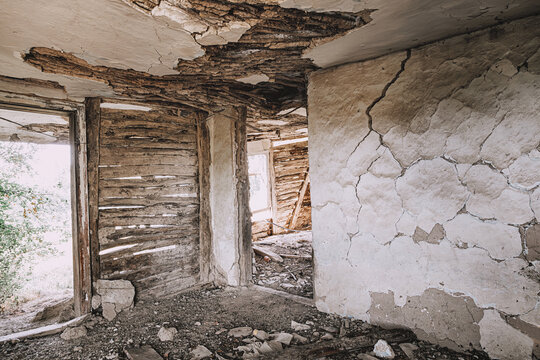 Wide-angle interior view of a crumbling abandoned building with