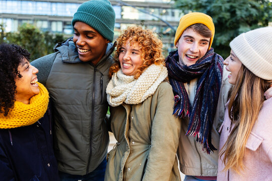 Multi-ethnic group of young students laughing and enjoying time together on a winter day outdoors