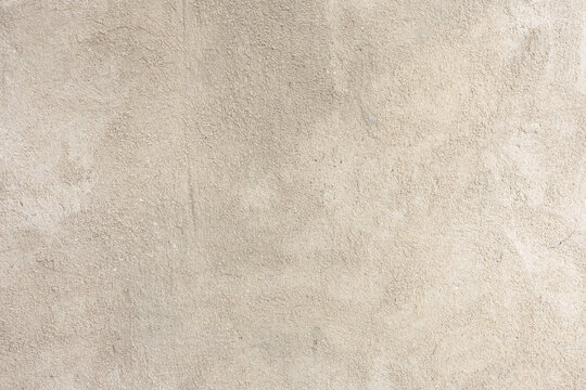 Beige plaster texture, close-up of light concrete wall with old rough surface, textured abstract background.