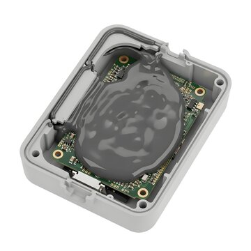 Electronic circuit board inside a plastic housing protected by a layer of grey epoxy resin.