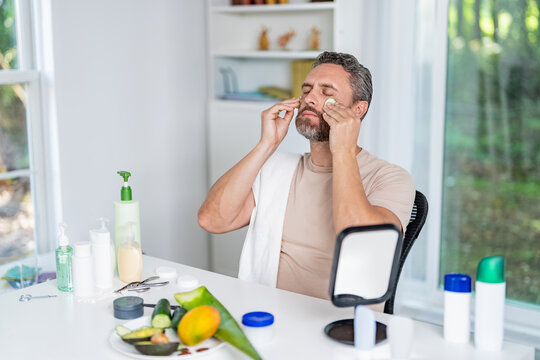 Benefits of vitamin C. Man applying facial care with cucumber. Cosmetic procedure man with cucumber slices on face. Man fill skin with vitamin. Man with healthy cucumber. Spa relaxation