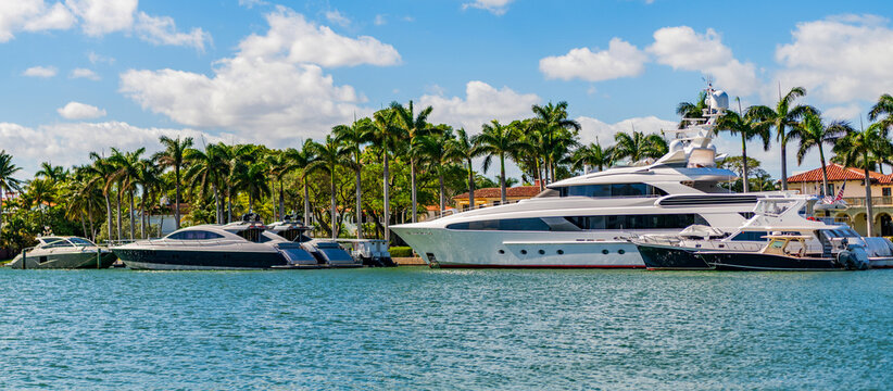 Luxury boat motor yacht in marina. Luxury yacht. Boating and yachting tourism. Luxurious lifestyle. Summer vacation. Docked yacht at private area. Residential luxurious apartment in waterfront city