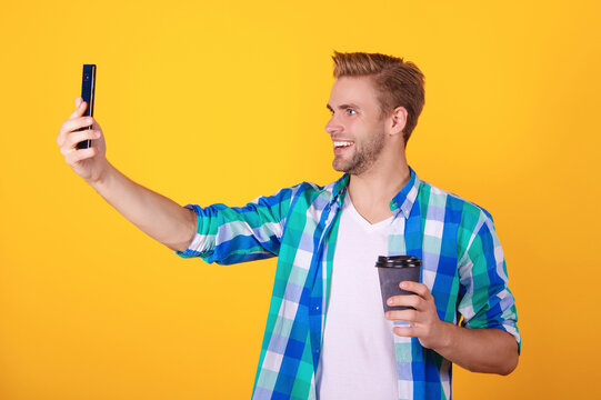 Millennial man making selfie. Video blog. Video call communication. Man making video blog isolated on yellow. Smartphone selfie. Blogging on selfie. Stylish influencer on video call