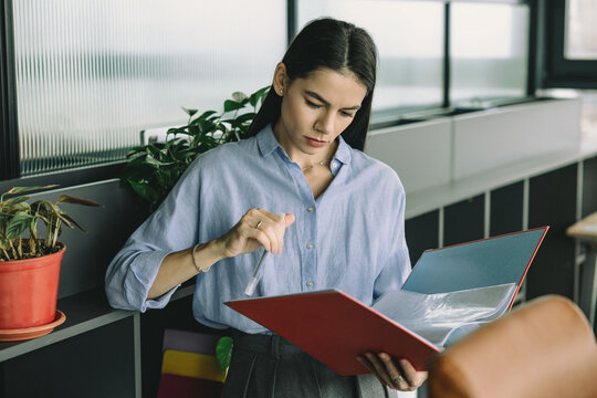 Data analysis. Checklist business report. Business professional woman reading paper financial report. Woman working analyzing financial document. Woman planning. Businesswoman busy in planning