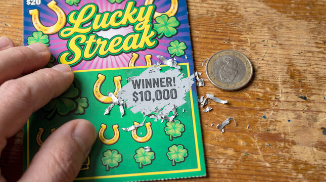 Lottery scratch card with a winning combination and a coin