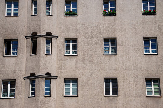 Textured historic facade in Vienna featuring varied window projections, geometric repetition, and flower boxes, creating an understated European architectural scene for travel and editorial use.