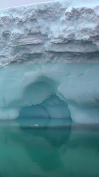 Glistening icebergs float serenely in frigid waters of Antarctica. Unique shapes reveal stunning textures and colors as light dances across icy surface, showcasing nature's artistry at its finest.