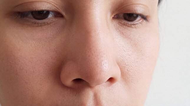 Extreme close up of a person's face showing detailed skin texture with pores slight imperfections facial skin
