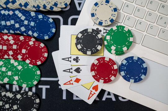 Top View of Laptop Keyboard with Four Aces Poker Cards and Multi Color Tokens for Web Gambling