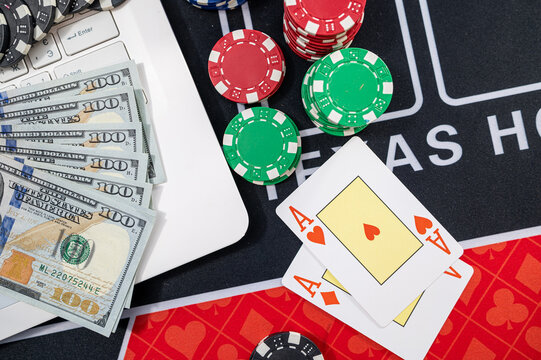White Laptop with US Dollar Bills Pocket Aces Cards and Casino Chips for Online Gambling Concept