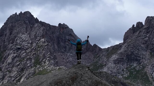 Backpacking woman hiking on flowering grassland mountain top	