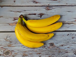 Flat Lay Yellow Bananas Bunch on White Rustic Wooden Desk © Алена Хопеева