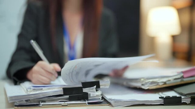 Female Office Worker Organizing and Reviewing Business Paperwork
