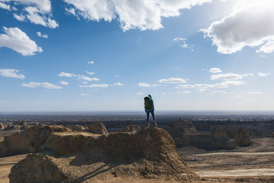 Successful female backpacker feel free on desert hill top