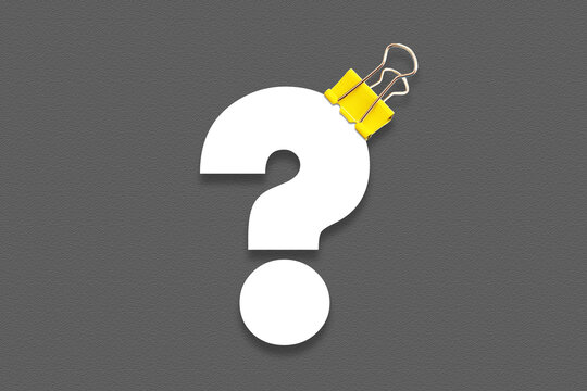 Question mark symbol with yellow metal clips on black background