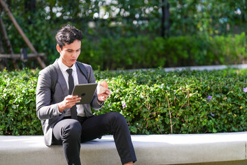 Obraz premium A confident multicultural business trio editing a document on a laptop on a bench at a public bench in the business district, capturing everyday collaboration in a modern workplace